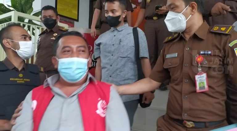 : Pemilik Bengkel di Warungdowo Pasuruan saat dibawa dari kantor Kejari ke mobil tahanan. (mahfud)