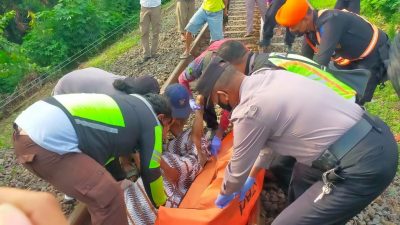 Petugas kepolisian mengevakuasi jasad kakek yang tersambar Kereta Api komuter di Gempol, Kabupaten Pasuruan, Kamis (24/02/2022).