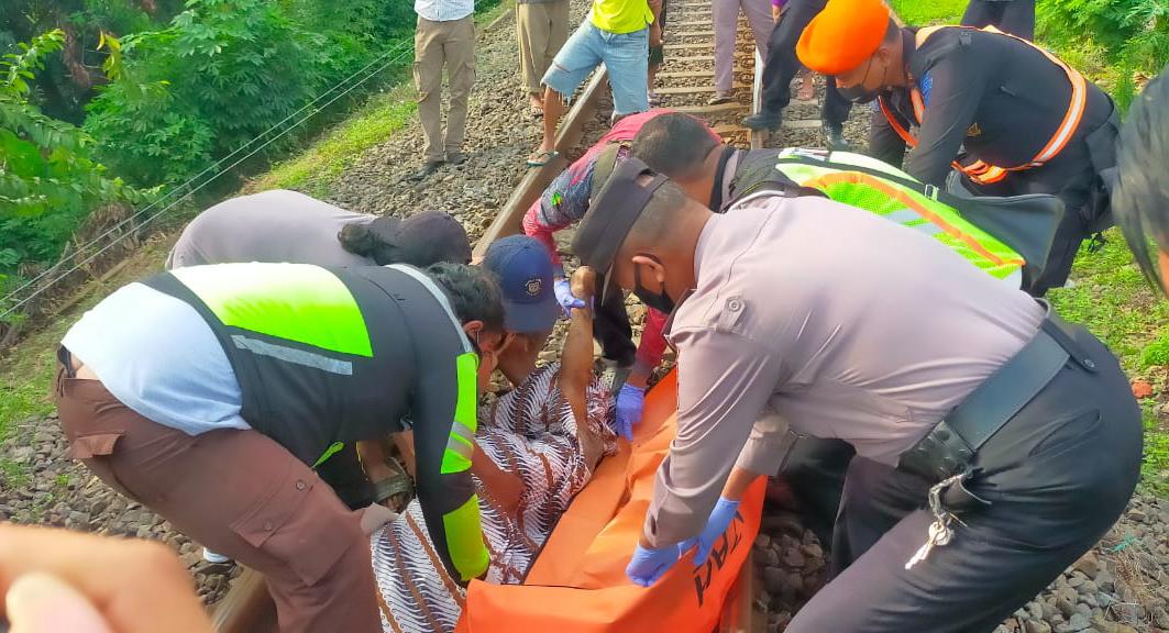 Petugas kepolisian mengevakuasi jasad kakek yang tersambar Kereta Api komuter di Gempol, Kabupaten Pasuruan, Kamis (24/02/2022).