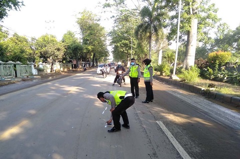 Petugas kepolisian melalukan olah TKP kecelakaan pemotor yang dilindas bus di Blandongan, Pasuruan, Senin (8/2/2022).