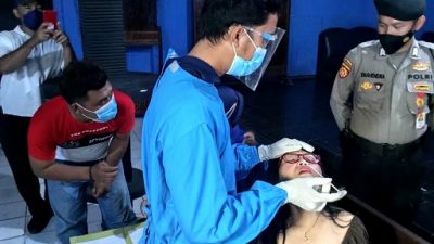 Petugas kesehatan melakukan tes swab kepada karyawan tempat hiburan malam.