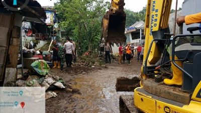 Sisa material banjir dibersihkan oleh petugas.