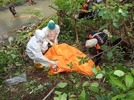 Petugas mengevakuasi jasad pria membusuk di pinggir sungai desa Bajangan, Gondangwetan, Kabupaten Pasuruan pada Minggu (06/03/2022).