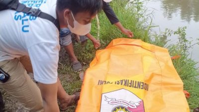 Petugas kepolisian mengevakuasi jasad bayi hanyut di sungai dusun Krawan, desa Kedawung Wetan, Kecamatan Grati, Kabupaten Pasuruan, Minggu (27/03/2022) sore.