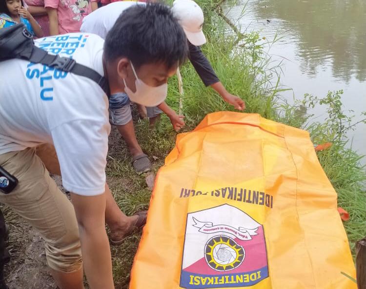 Petugas kepolisian mengevakuasi jasad bayi hanyut di sungai dusun Krawan, desa Kedawung Wetan, Kecamatan Grati, Kabupaten Pasuruan, Minggu (27/03/2022) sore.