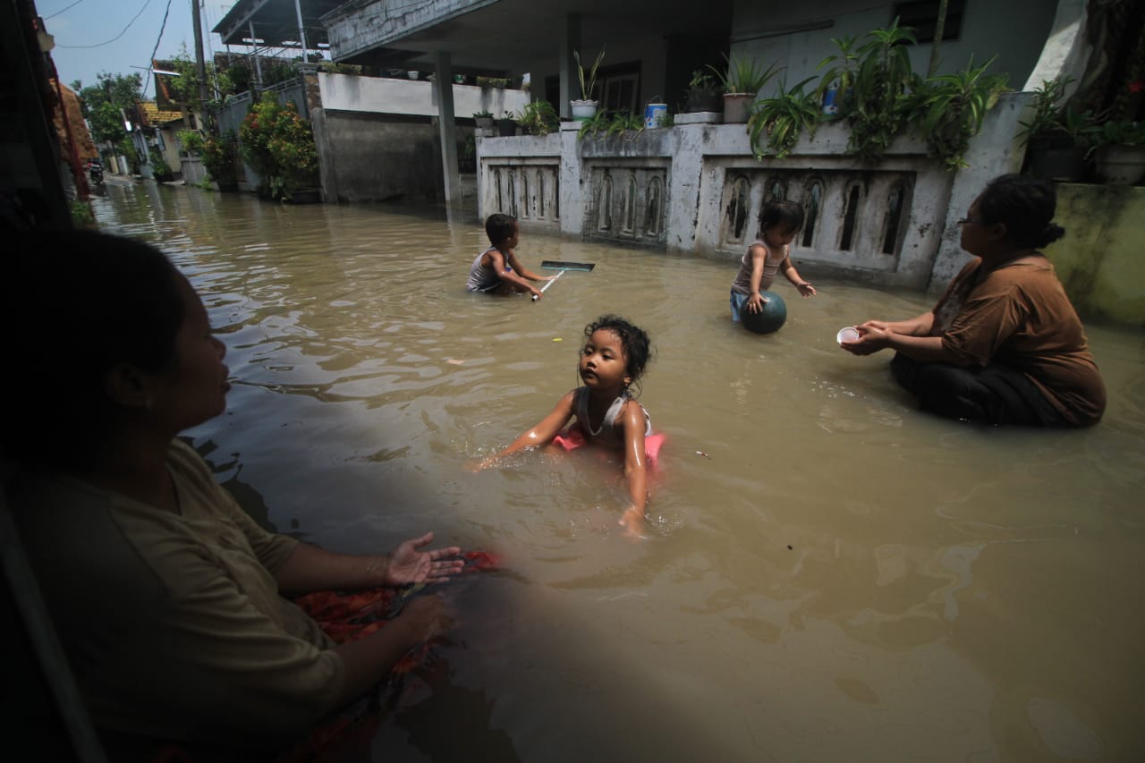 Warga dusun Getas Kidul Pasuruan beraktifitas di antara genangan banjir.