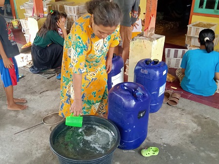 Siti Fatimah (57) saat berada di kediamannya di Desa Ledok Kulon, Kecamatan/Kabupaten Bojonegoro, Rabu (09/03/2022). Dia menunjukan air bercampur minyak goreng yang dibelinya dari oknum penjual minyak goreng palsu.