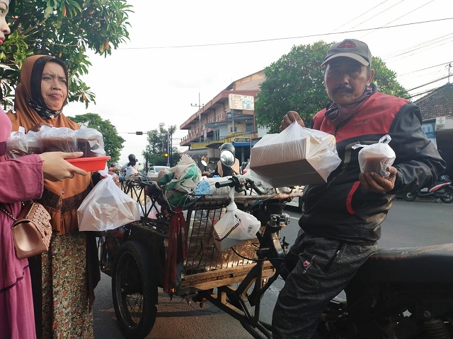Salah satu warga Kota Malang menerima menu buka puasa dan minyak goreng gratis pada Jumat (15/04/2022).