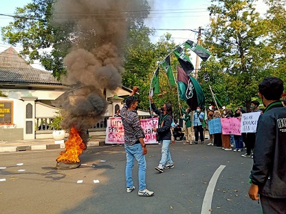 Sejumlah mahasiswa HMI Cabang Bojonegoro melakukan orasi sambil bakar ban di depan gedung DPRD Bojonegoro, Kamis (14/04/2022).