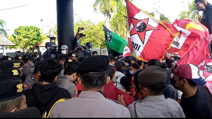 Massa aksi mahasiswa saling dorong dengan petugas kepolisian saat dihalangi masuk ke dalam gedung DPRD Tuban, Kamis (14/4/2022).