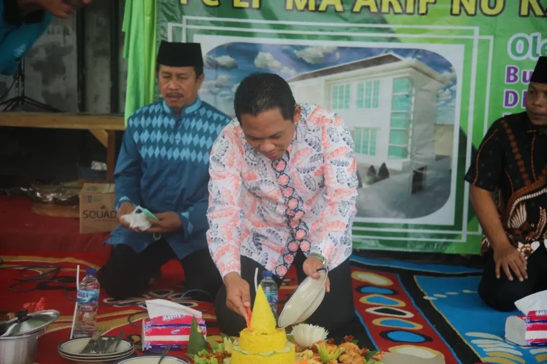 Bupati Lumajang, Thoriqul Haq, memotong tumpeng sebelum peletakan batu pertama PC LP Ma'arif NU.