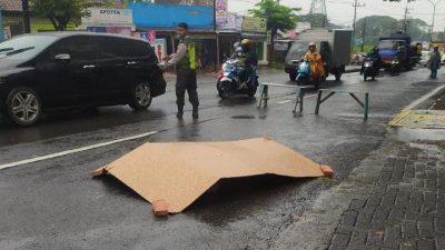 Jasad pemotor yang tewas terlindas truk tangki di Kecamatan Sukorejo, Kabupaten Pasuruan.