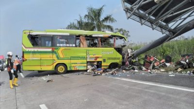 Bus yang mengangkut warga Benowo Surabaya ringsek setelah menabrak tiang penunjuk jalan di tol Mojokerto pada Senin (16/5/2022).