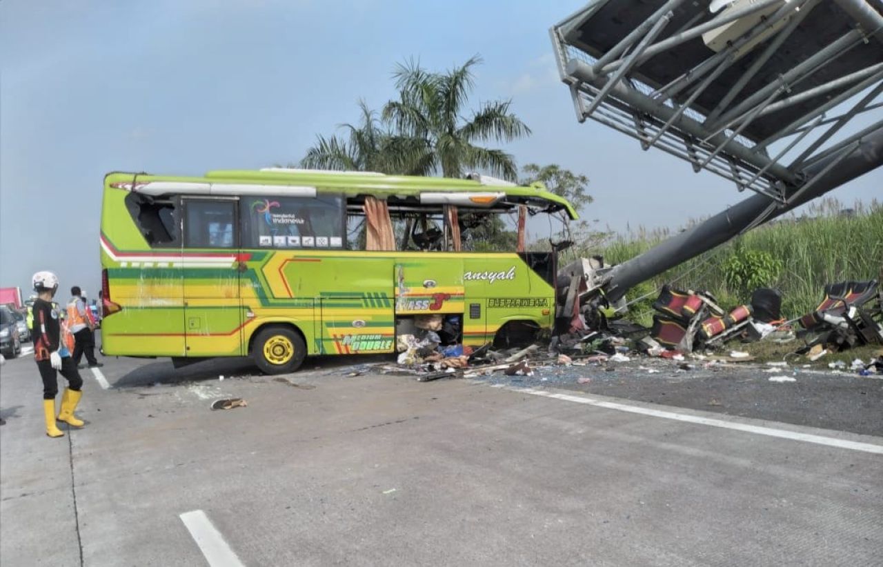 Bus yang mengangkut warga Benowo Surabaya ringsek setelah menabrak tiang penunjuk jalan di tol Mojokerto pada Senin (16/5/2022).