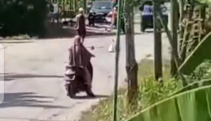 Tangkapan layar video yang memperlihatkan seorang pria tengah ngamuk dan membawa senjata tajam mengancam warga yang melintas di persimpangan tiga jalan desa di Tuban.