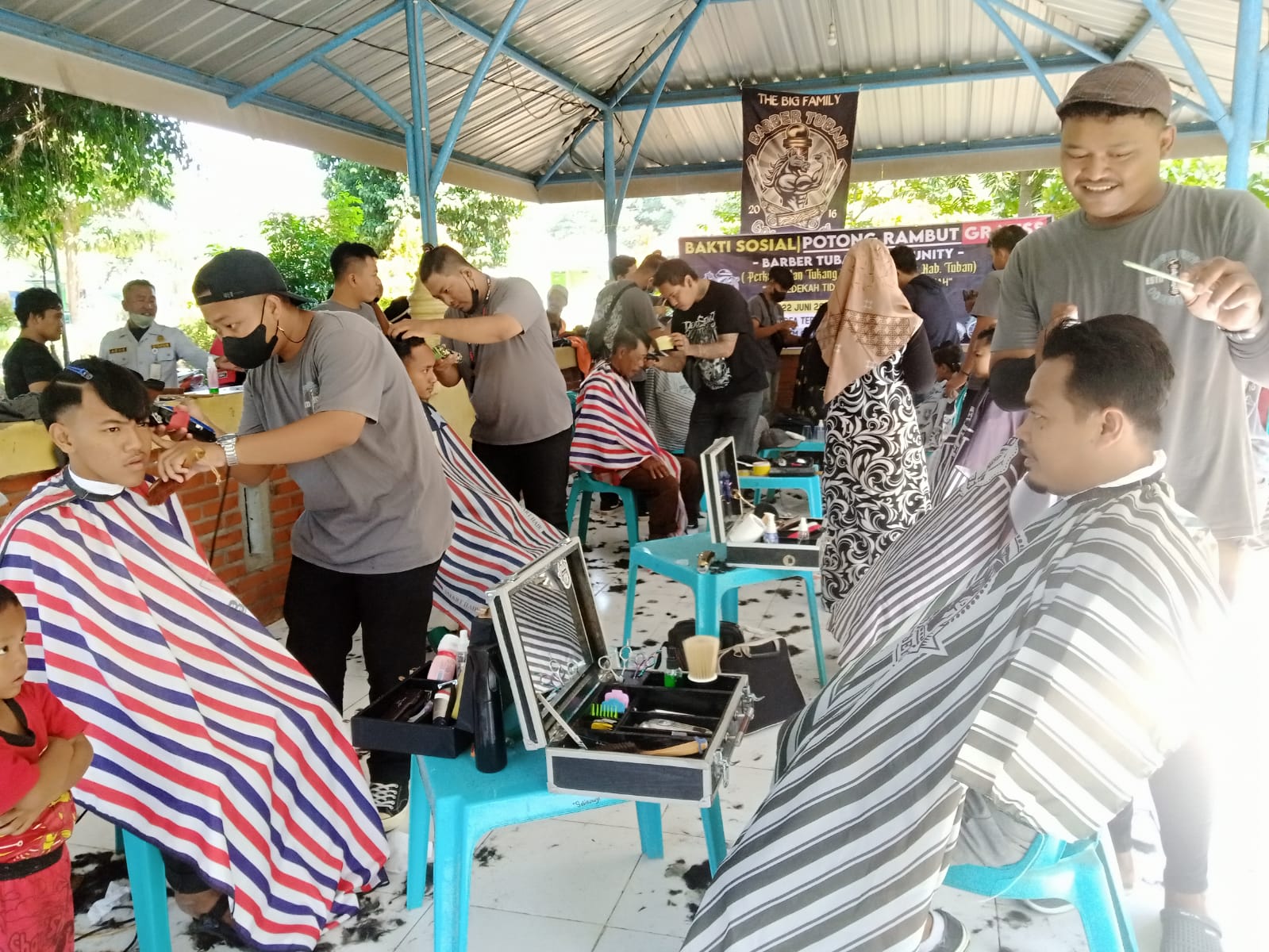Tampak sejumlah tukang potong yang sibuk merapikan rambut warga yang ikut bakti sosial yang digelar Barber Tuban Community atau Perkumpulan Tukang Cukur Rambut se-Kabupaten Tuban. 