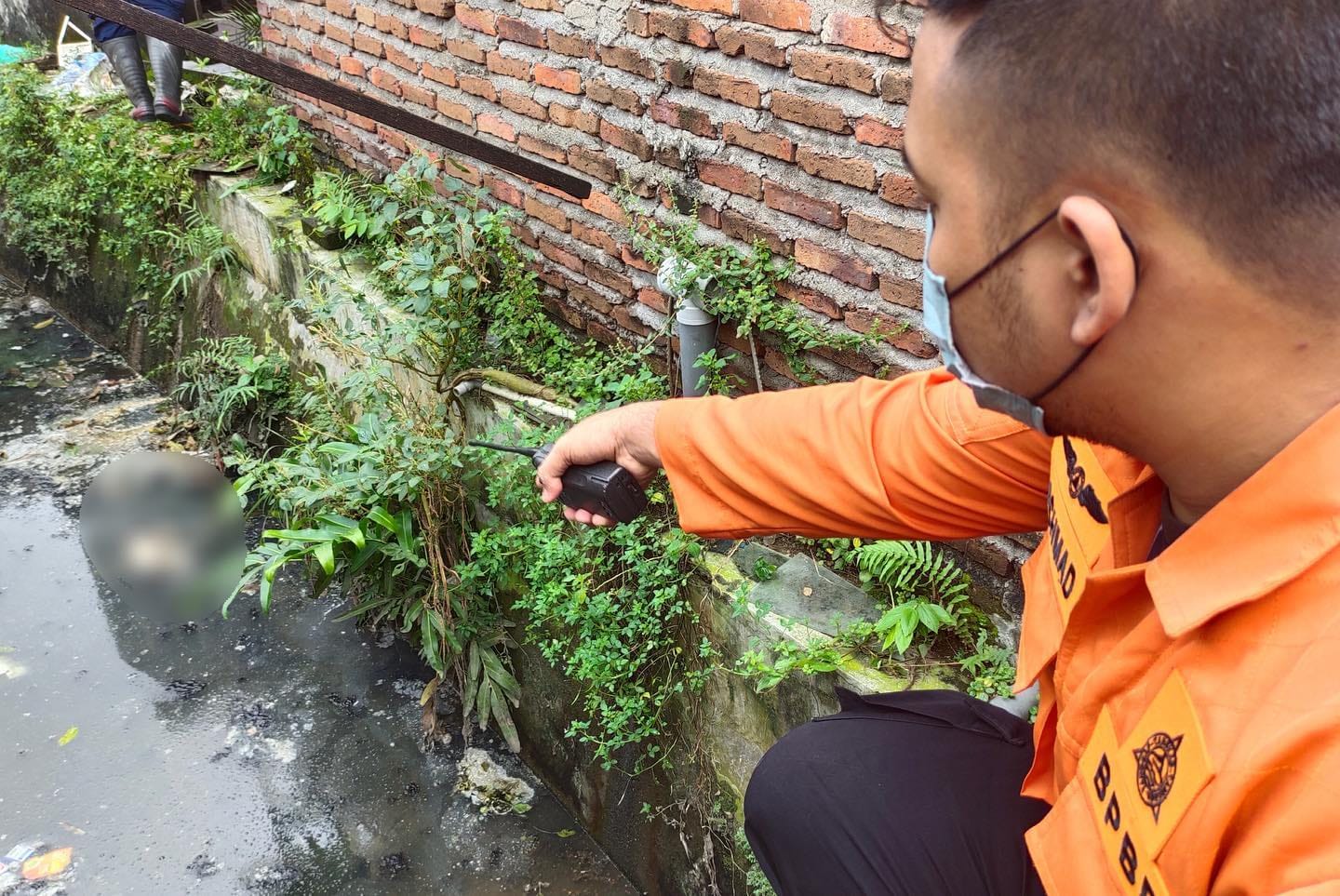 Petugas menunjukkan lokasi penemuan mayat bayi yang mengapung di selokan Jemur Ngwaninan Surabaya.