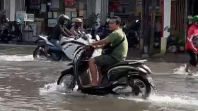 Salah satu warga Pandugo Kota Surabaya yang menerjang banjir.