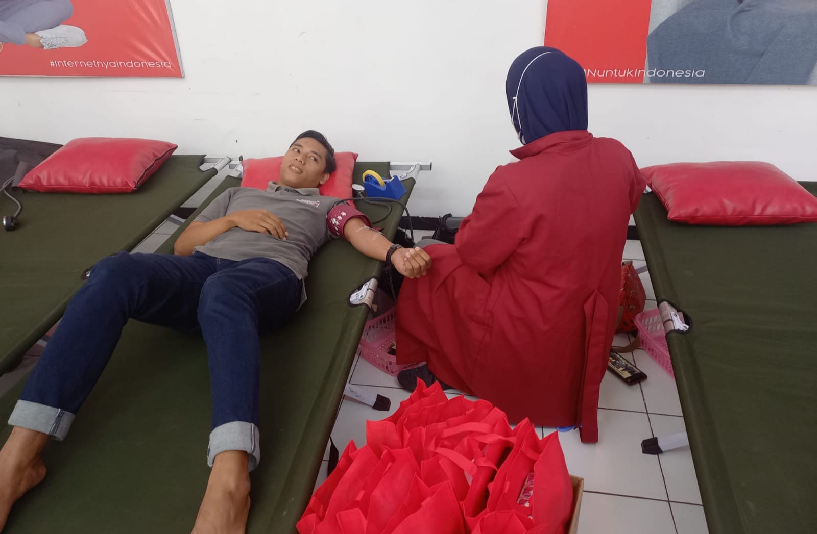 Achmad Baidowi (partisipan) dan Lailatul Ashurin (petugas Aftap) sedang melakukan kegiatan donor darah di Telkom Pasuruan, Selasa (14/6/2022).