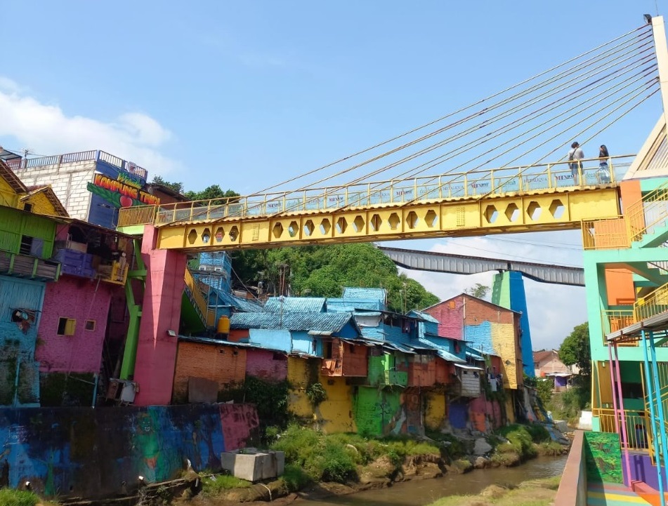 Potret wisatawan di atas jembatan kaca ikon penghubung kampung tridi dan kampung warna-warni.