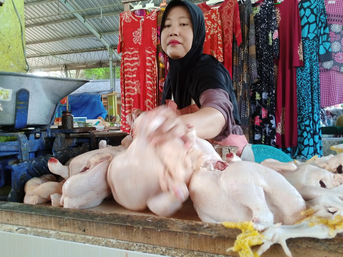 Suyatmi, pedagang daging ayam di Pasar Pramuka Tuban saat melayani pembeli.