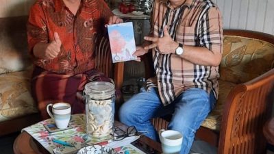 Dr Aqua Dwipayana bersama Prof Deddy Mulyana, MA., PhD memegang buku Pada Suatu Musim Semi.