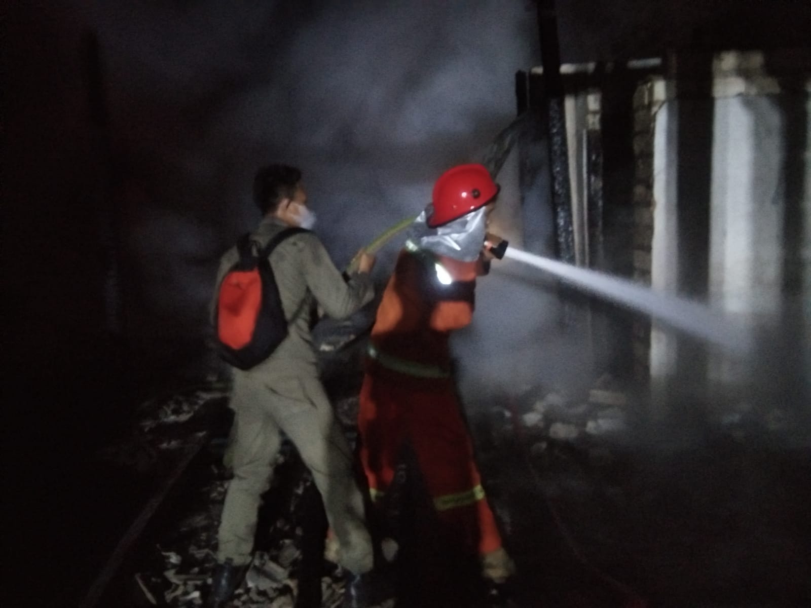 Petugas Pemadam kebakaran dibantu Polisi, TNI dan masyarakat bersama-sama memadamkan api dalam kejadian kebakaran rumah joglo di Desa Tluweh, Kecamatan Soko, Tuban pada Senin (4/7/2022) malam.