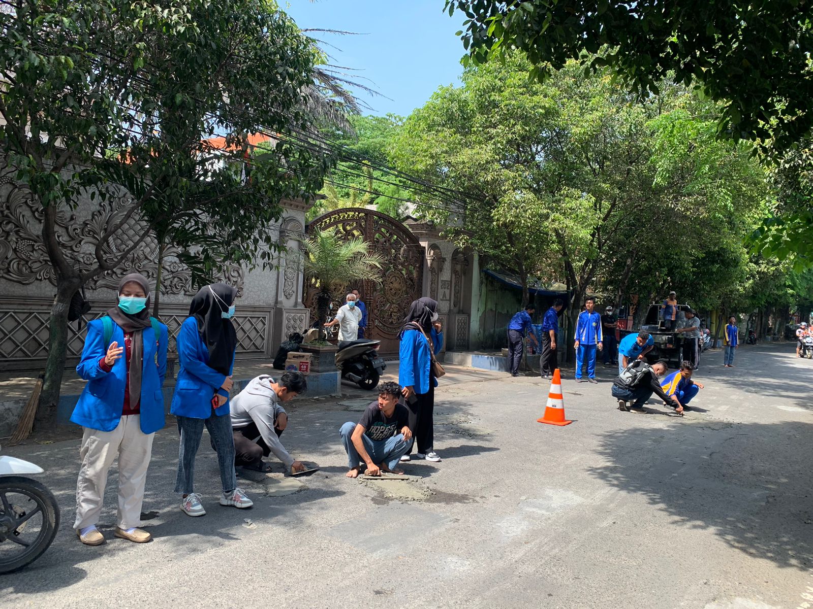 Puluhan mahasiswa dan pelajar sekolah Yayasan Yadika gelar aksi tambal lubang di sepanjang jalan Ikan Paus di Kecamatan Bangil, Kabupaten Pasuruan.