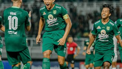 Kapten Persebaya, Rizki Ridho, berlari ke arah pemain asing Persebaya asal Brazil, Higor Vidal, untuk merayakan gol.