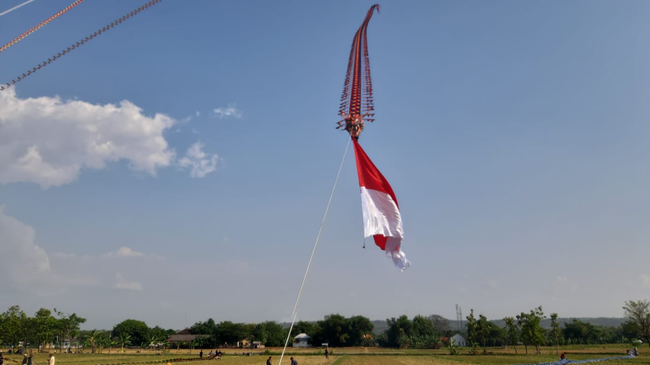 Momentum layang-layang naga mengibarkan bendera merah putih di langit wilayah Desa Kembangbilo, Kecamatan/Kabupaten Tuban.