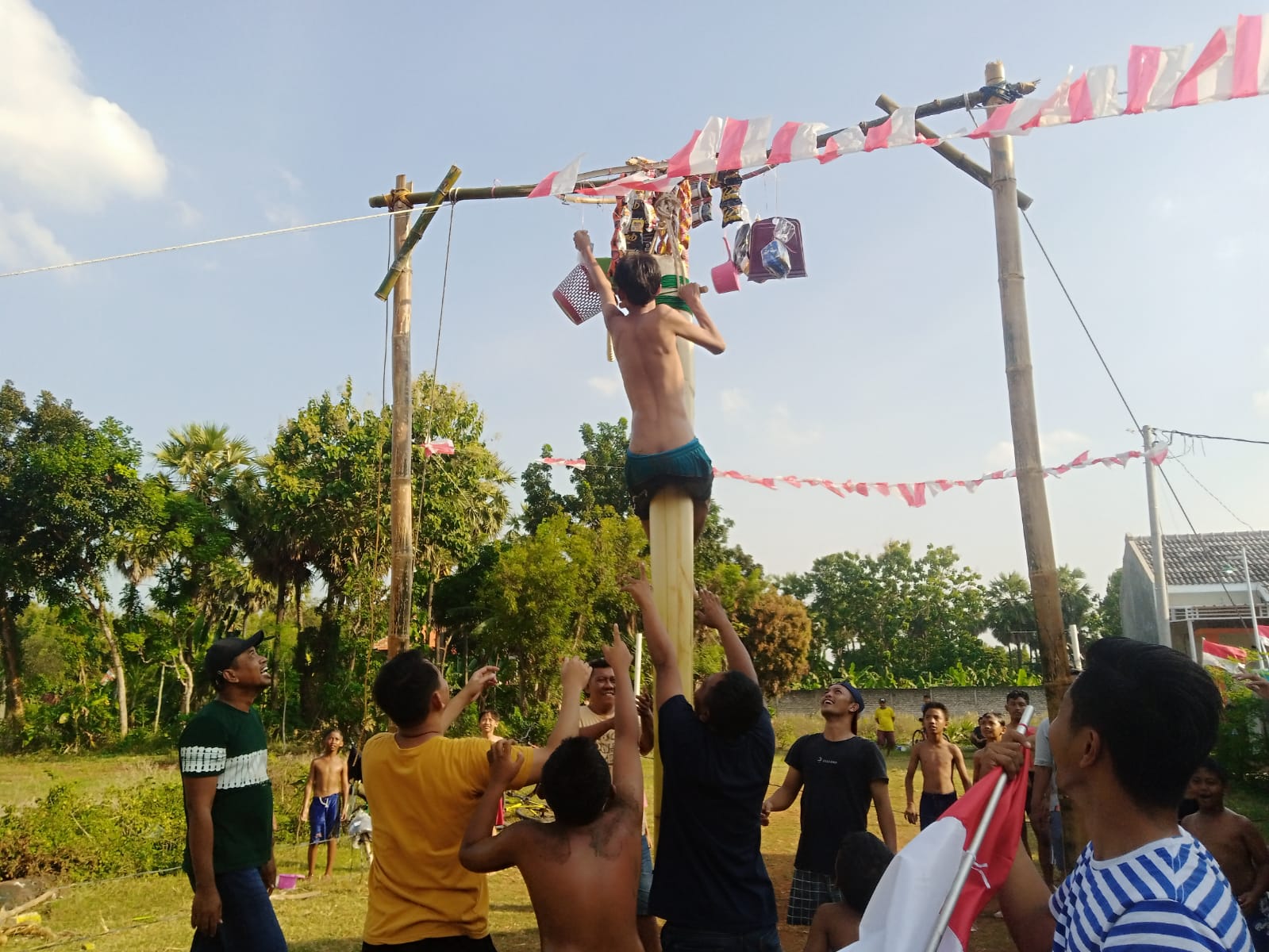 Sejumlah anak muda berusaha memanjat batang pohon pisang atau gedebog untuk mendapatkan hadiah di puncak.