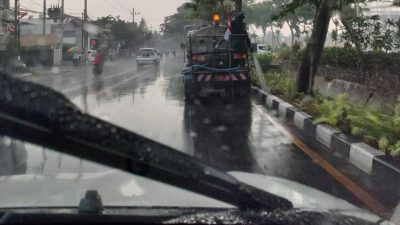 Mobil tangki air milik pemkot Surabaya yang menyiram taman saat hujan.