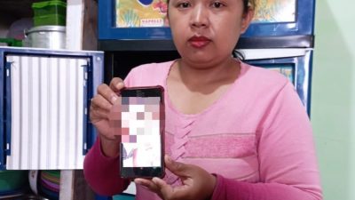 Pita Widyanti (34), ibu RY (12) menunjukkan foto putrinya yang belum pulang selama 10 hari.