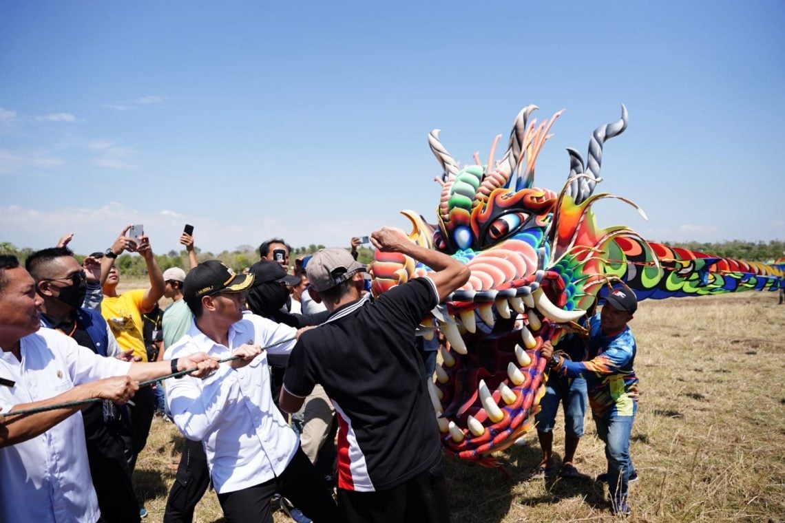 Bupati Tuban, Aditya Halindra Faridzky mencoba seberapa berat layang-layang naga yang ikut Festival Layang-layang Nasional. Foto: Diskominfo Tuban