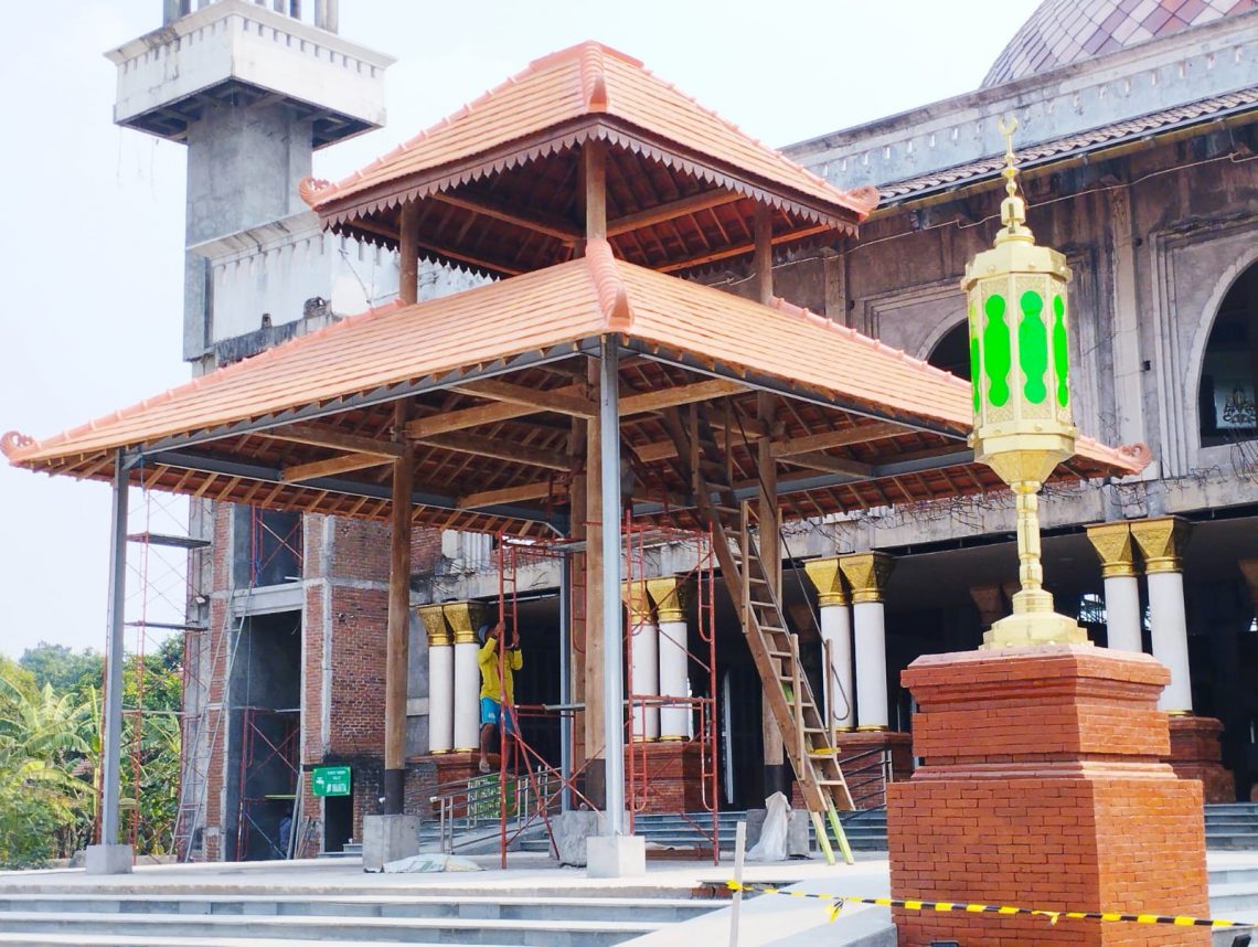 Pekerja mengecek kondisi soko guru setelah kembali berdiri tegak. Foto: Hanif Nanda/Tugu Jatim