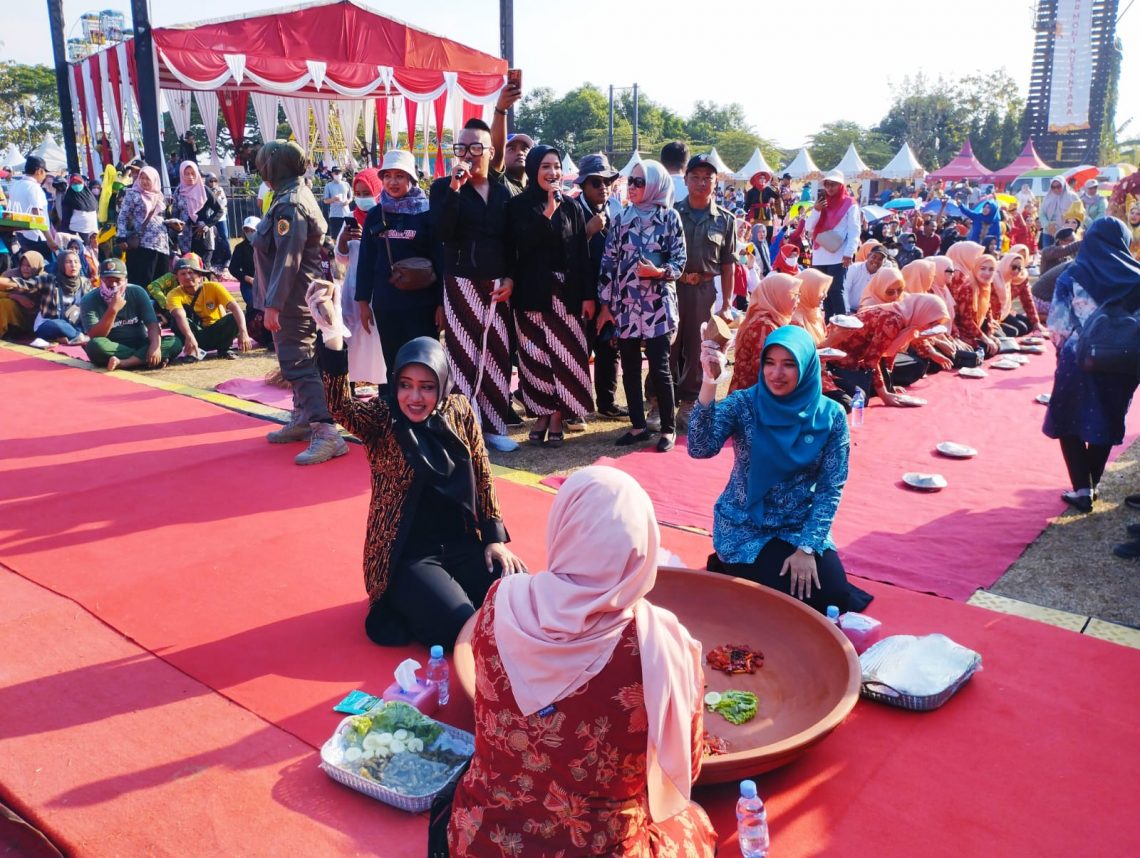 Bupati Mojokerto, Ikfina (kerudung hitam) dan Ketua TP PKK Kabupaten Mojokerto, Shofiya Hanna (baju biru) mengulek sambel wader. Foto: Hanif Nanda/Tugu Jatim