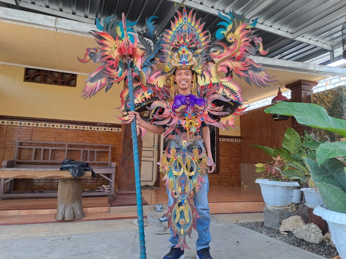 Penyewa baju karnaval asal Kelurahan Panyuran, Kecamatan Palang, Kabupaten Tuban, Khoirul Huda mencoba kostum karnaval. Foto: Rochim/Tugu Jatim
