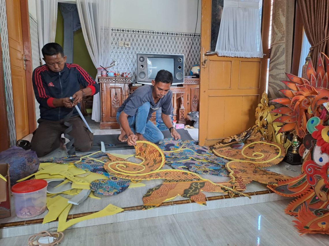 Agus Heri Susilo (kiri) membuat kostum karnaval. Foto: Rochim/Tugu Jatim