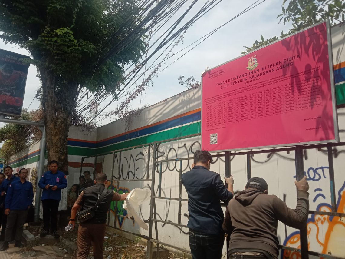 Kejagung RI memasang plang penyitaan lahan proyek pembangunan Apartemen Nayumi Sam Tower di Malang. Foto: M Sholeh/Tugu Jatim