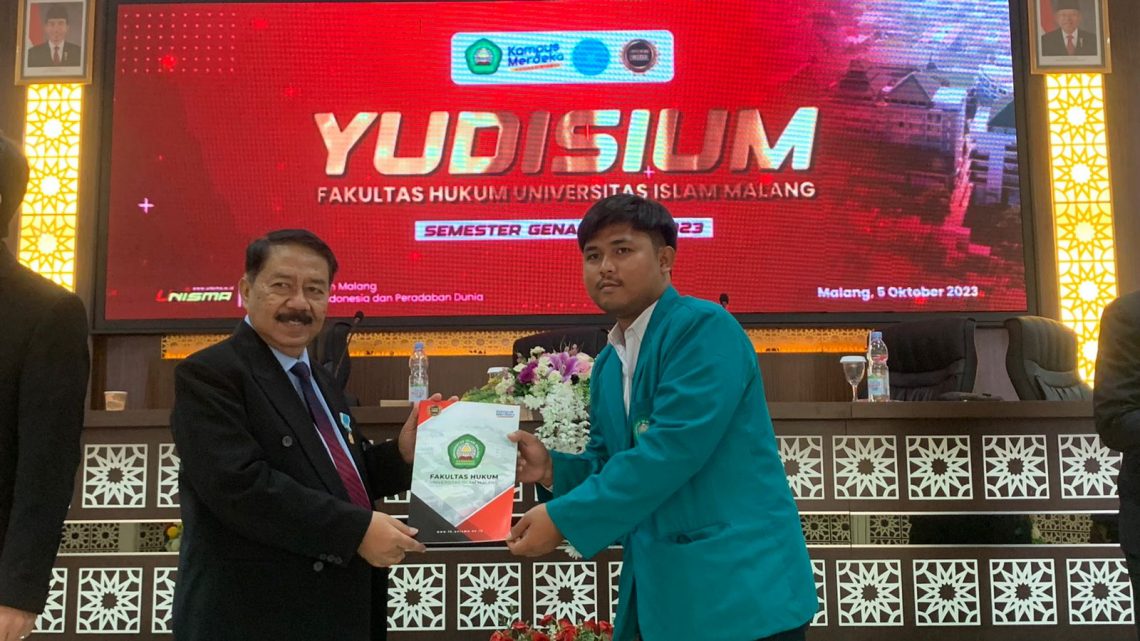 Dekan FH Unisma menyerahkan SKL kepada salah satu lulusan. Foto: Feni Yusnia/Tugu Jatim