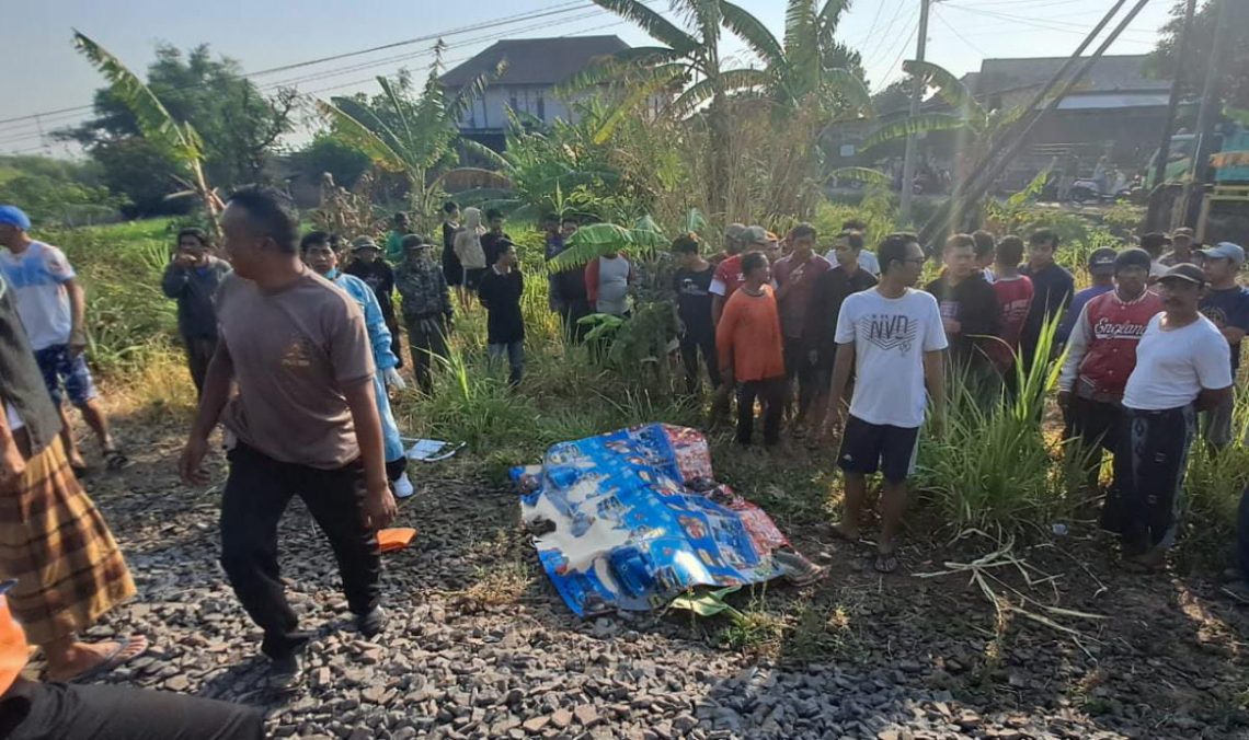 Warga mengerubungi jenazah Sahid (43), pria yang tertabrak kereta api hingga tewas di Dusun Pandean, Desa Sengonagung, Kecamatan Purwosari, Kabupaten Pasuruan, pada Sabtu (7/10/2023) pagi. Foto: dok Polsek Purwosari