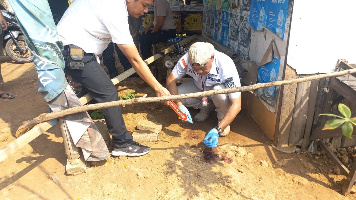 Polisi memeriksa lokasi ditemukannya pria bersimbah darah di samping warung pinggir Jalur Pantura, di Desa Bendungan, Kecamatan Kraton, Kabupaten Pasuruan, pada Rabu (3/11/2023). Foto: Laoh Mahfud/Tugu Jatim