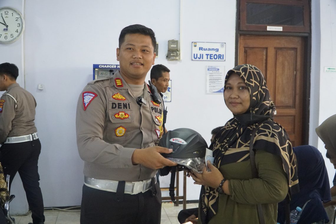 Kasatlantas Polres Pasuruan, AKP Deni Eko Prasetyo memberikan hadiah helm dan jaket keselamatan berlalu lintas untuk warga pemohon SIM di Satpas Satlantas Polres Pasuruan, pada Jumat (10/11/2023). Foto: Laoh Mahfud/Tugu Jatim