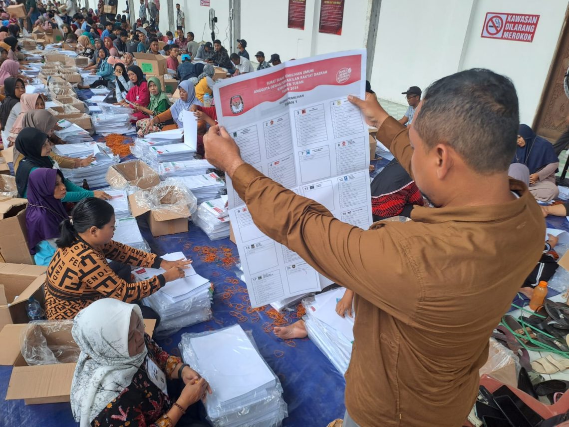 Ketua KPU Kabupaten Tuban, Fatkul Iksan mengecek surat suara saat proses penyortiran dan pelipatan di gudang logistik KPU Kabupaten Tuban. Foto: Rochim/Tugu Jatim