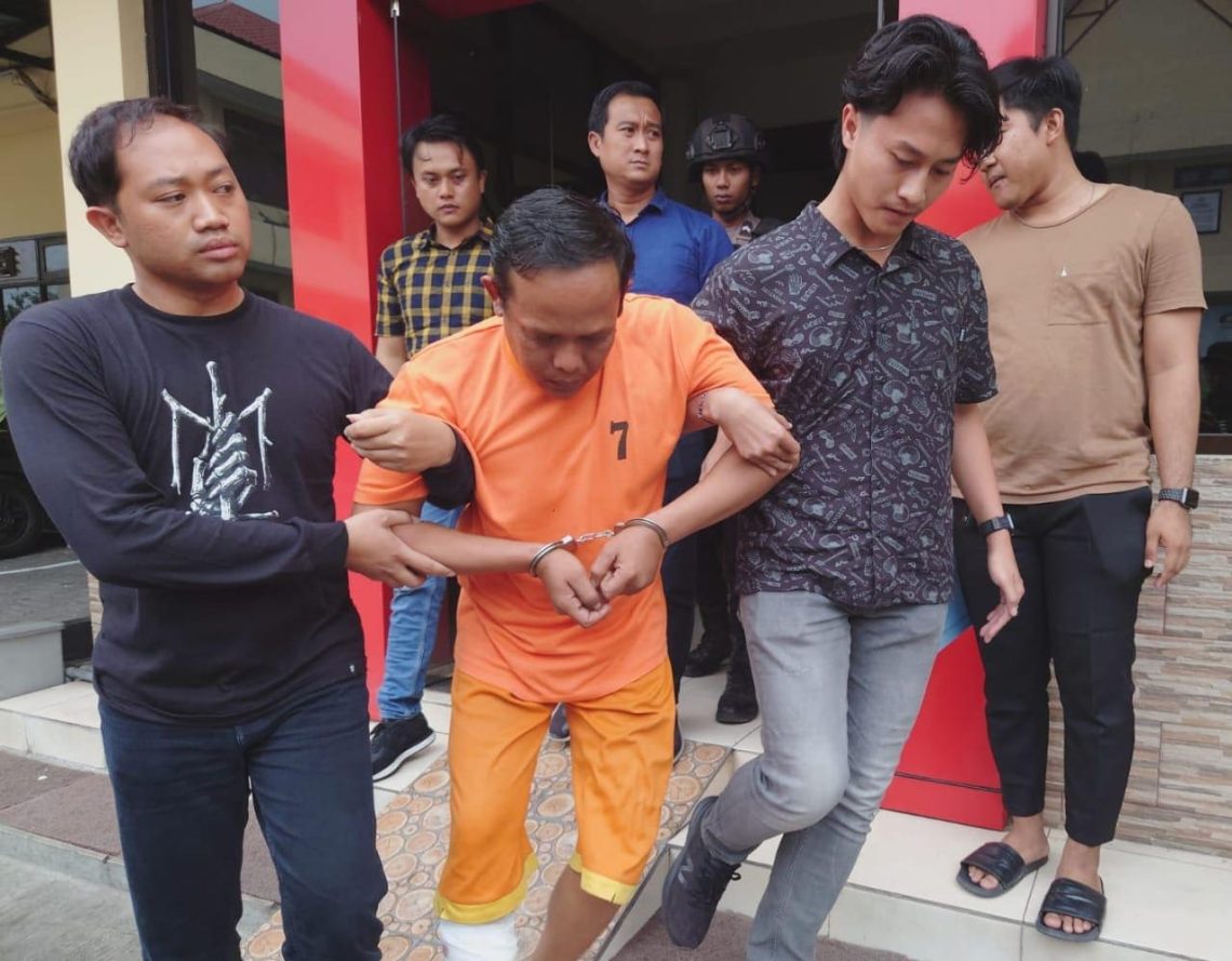Pelaku pembunuhan mayat yang dibuang di Mojokerto saat digelandang polisi. (Foto: Hanif Nanda/Tugu Jatim)