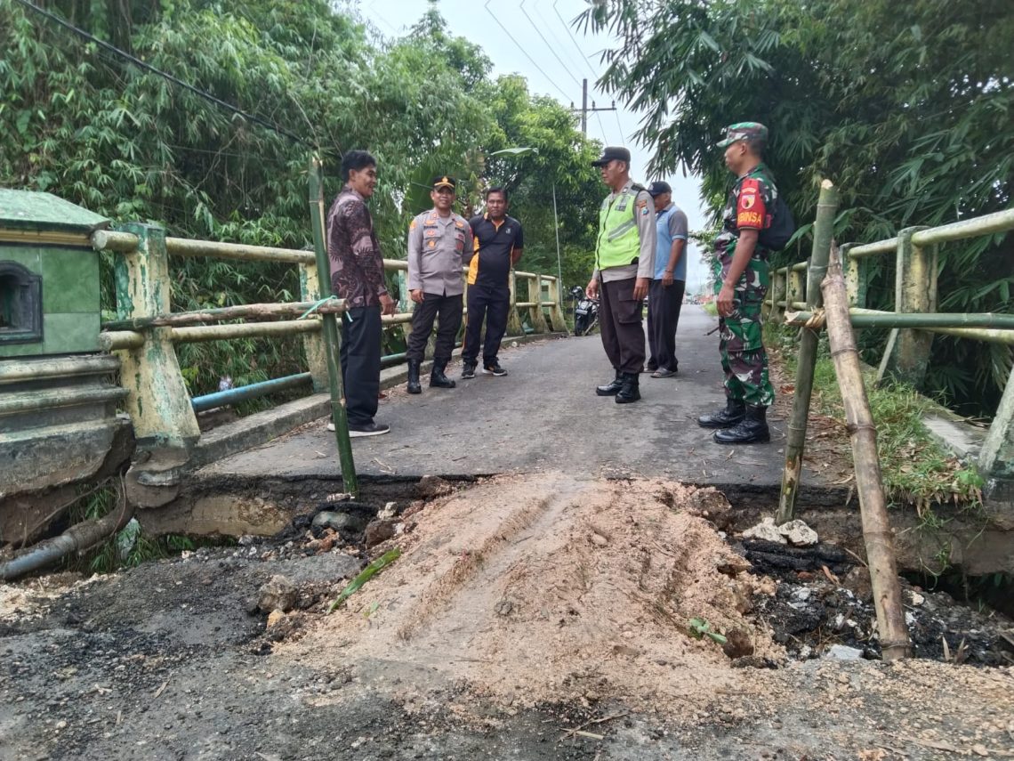 Pemkab Tuban Renovasi Total Jembatan Amblas di Bangilan 1 Kapolsek Bangilan, AKP Rukandar bersama Komandan Koramil dan pejabat setempat meninjau lokasi jembatan penghubung desa yang amblas. foto dok.istimewa