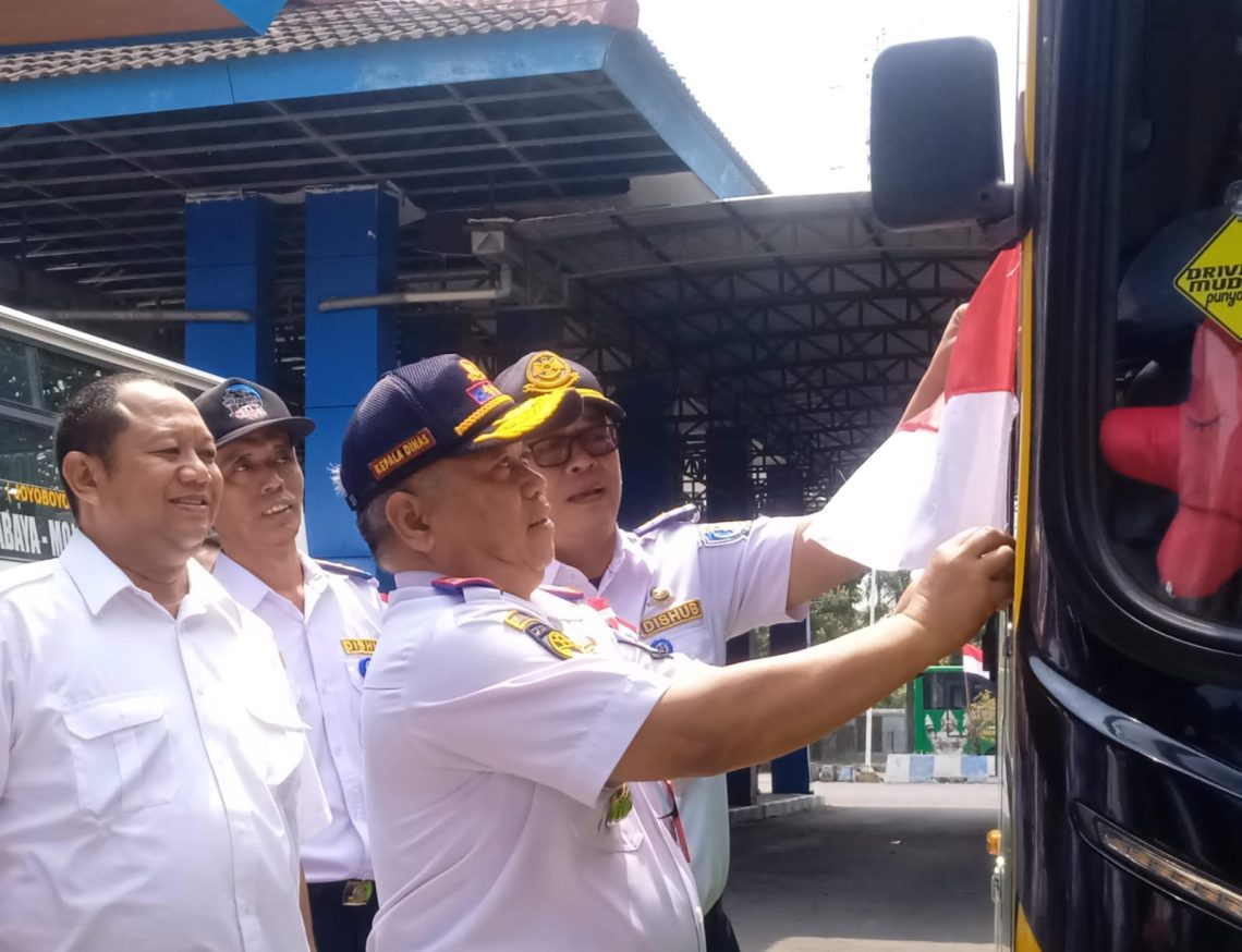 Dishub Jatim Bagi Bendera Merah Putih dan Program Trans Jatim Gratis di HUT RI 1 Kadishub Jatim, Nyono memasang bendera di salah satu bus di Terminal Mojokerto (Hanif)