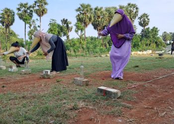 Lomba Isi Air ke Botol Kenakan Topeng Contong