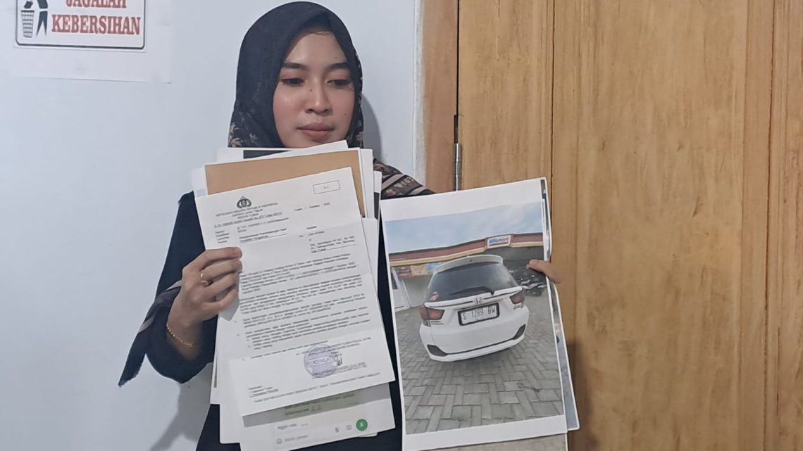Lisa Afiana (29) memperlihatkan laporan polisi dan juga foto mobil yang diduga digelapkan oleh terlapor. Foto dok. Rochim